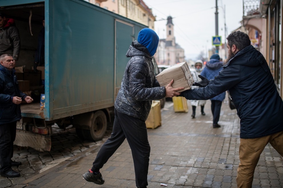 Varias personas descargan un camión con donaciones para un centro de refugiados ucranianos, a 4 de marzo de 2022, en el oeste de Ucrania.