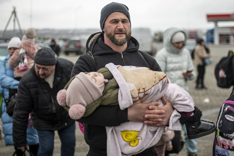 05/03/2022 Un hombre sostiene a un bebé en brazos en el paso fronterizo de Porubne, en el oeste de Ucrania