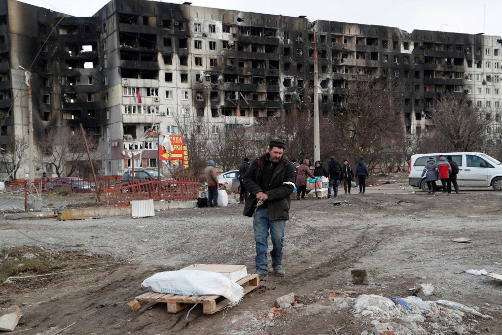 Un hombre recoge sus pertenencias cerca de un bloque de pisos destruido destruido tras un bombardeo en Mariupol.