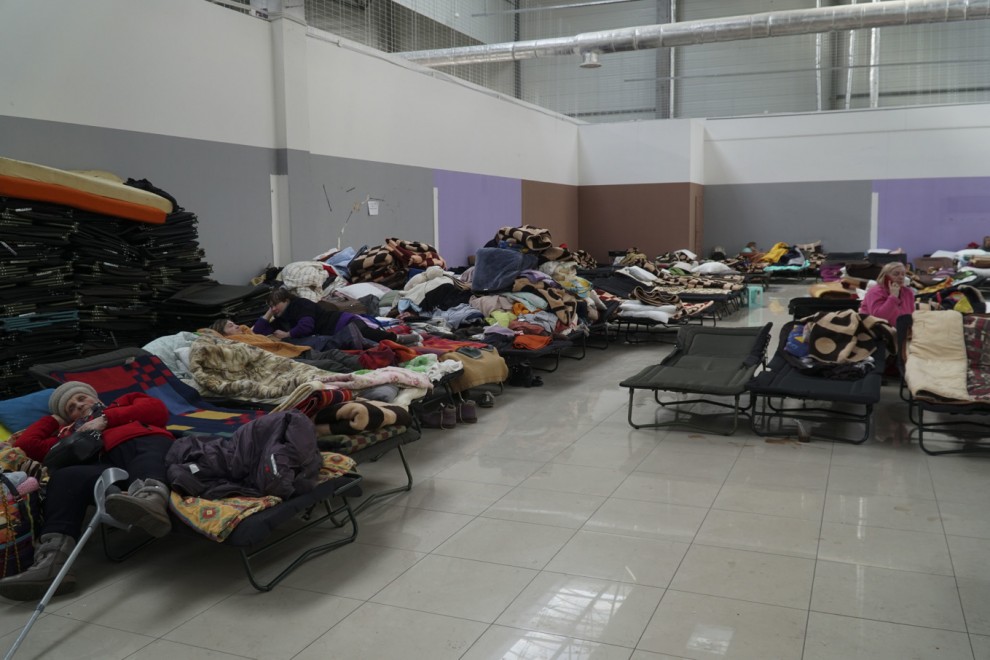 Refugiados ucranianos descansan sobre camas plegables en un centro comercial reconvertido en punto de acogida de refugiados ucranianos en la ciudad polaca de Korczowa, cerca de la frontera con Ucrania.