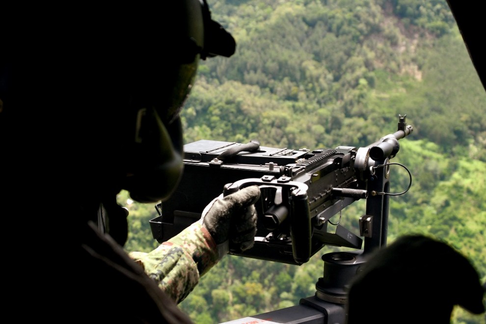 Un soldado permanece en posición en un helicóptero que sobrevuela la zona donde fuerzas militares -en la víspera- capturaron al narcotraficante Dairo Antonio Úsuga, alias Otoniel, cerca de Carepa, departamento de Antioquia, Colombia, el 24 de octubre de 2