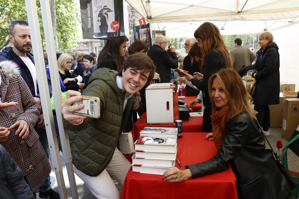 a escritora María Dueñas posa para una foto mientras firma ejemplares de sus libros en el Paseo de Gràcia con motivo de la celebración de Sant Jordi en Barcelona este sábado.
