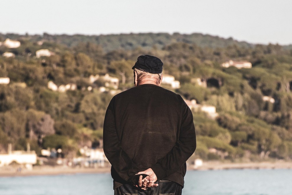 Un hombre mayor observa el mar.
