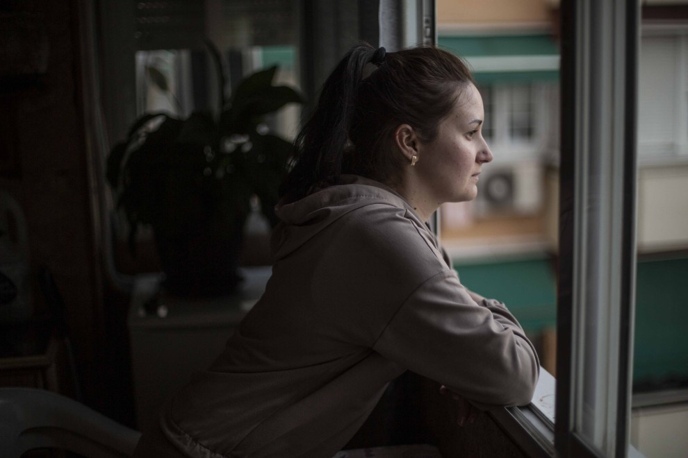 Daria Tatarina, de 29 años, en la ventana del piso de su prima, en Móstoles, a donde llegó tras una semana de viaje desde Jersón, al sur de Ucrania, bajo control ruso.