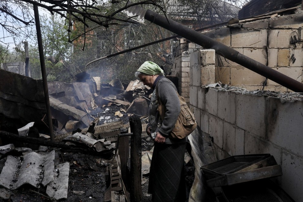 14/05/2022 Vera Kosolopenko camina entre los escombros de su vivienda, destruida por los bombardeos rusos en Derhachi, cerca de Járkov (Ucrania)