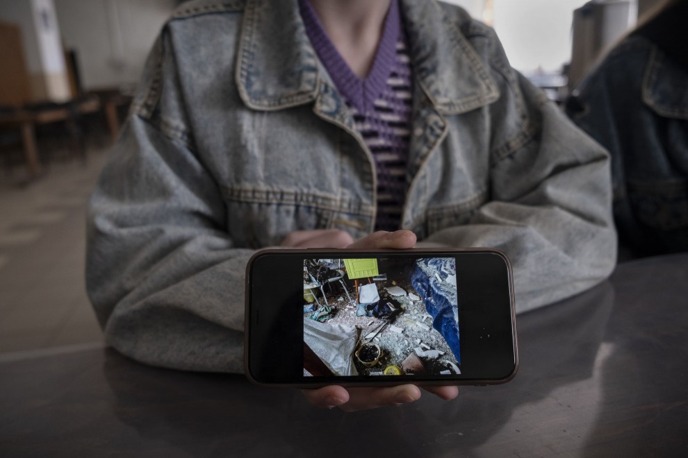 Annia muestra un fotografía en la pantalla de su teléfono móvil donde se ve cómo quedó su casa tras uno de los bombardeos que se producían a diario en Ruska Lozova (Járkiv)