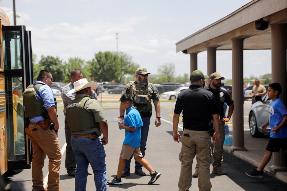 Los niños se suben a un autobús escolar mientras el personal policial vigila la escena de un presunto tiroteo cerca de la Escuela Primaria Robb en Uvalde, Texas, EE. UU. 24 de mayo de 2022.