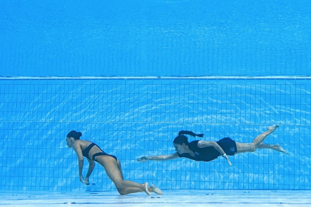 Un miembro del Equipo de EE. UU. (R) nada para recuperar a Anita Alvarez (L) de EE. UU., Del fondo de la piscina durante un incidente en las finales de natación artística libre en solitario de mujeres, durante el Campeonato Mundial Acuático de Budapest 20