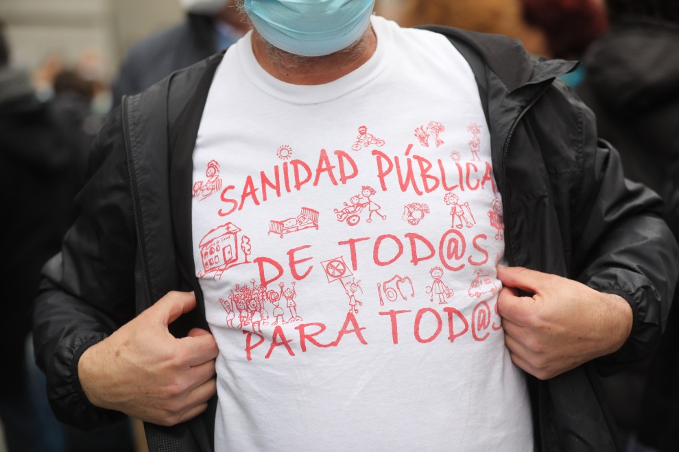 Un hombre, con una camisera que reza 'Sanidad pública de todos para todos' y 'Más sanitarios, muy necesarios', se manifiestan desde el Ministerio de Sanidad hasta la Puerta del Sol para apoyar la Atención Primaria, a 27 de marzo de 2022, en Madrid (España