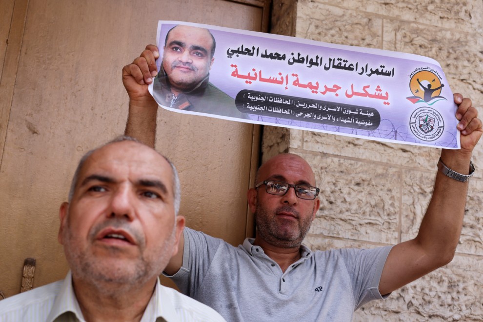 Un hombre sostiene una foto de Mohammad al Halabi, durante una protesta en solidaridad tras la decisión de un tribunal israelí de sentenciarlo a 12 años, en la ciudad de Gaza, el 30 de agosto de 2022.