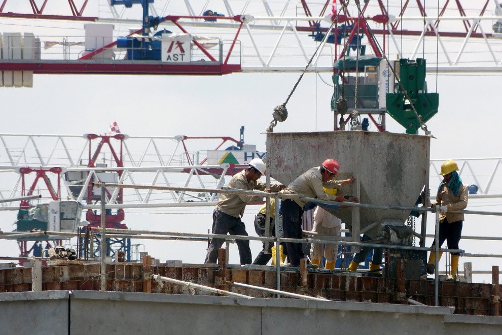 Fotografía de obreros sobre una construcción en horas de trabajo.