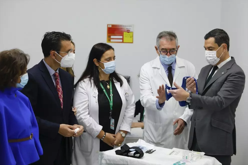 El presidente de la Junta, Juanma Moreno (d), junto a varios sanitarios en la presentación de 'Gammaknife' en el Hospital Virgen de las Nieves de Granada.