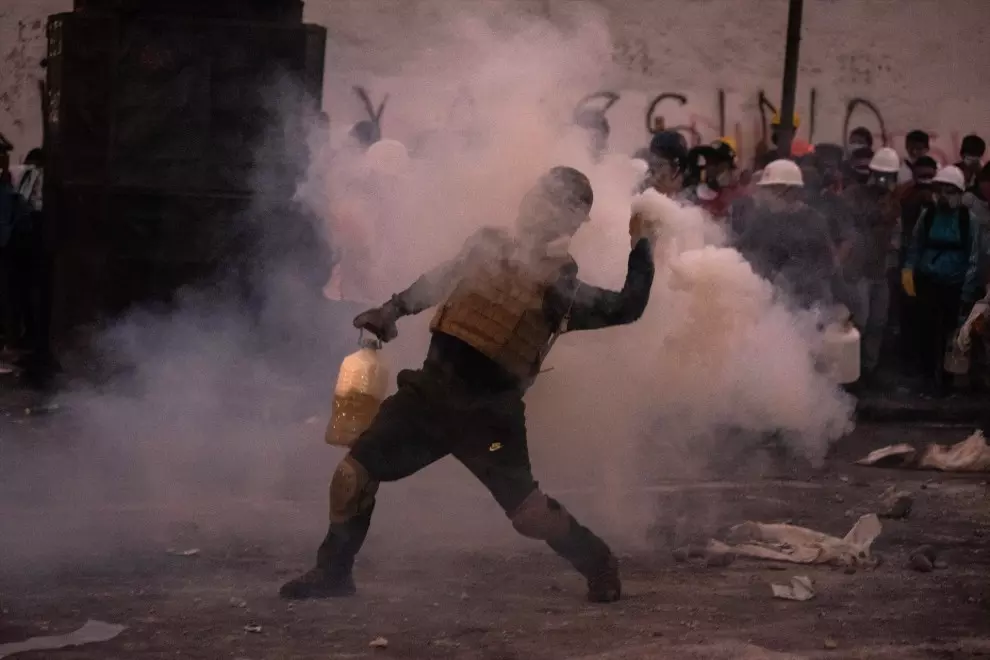 Un manifestante choca con la policía antidisturbios durante una protesta contra el gobierno de la presidenta peruana Dina Boluarte