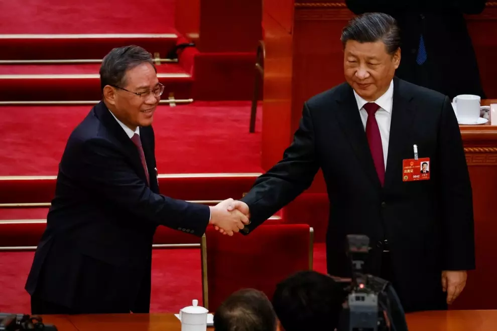 El presidente chino, Xi Jinping, le da la mano a Li Qiang (izquierda), nuevo primer ministro chino, durante la Tercera Sesión Plenaria de la Asamblea Popular Nacional (APN).