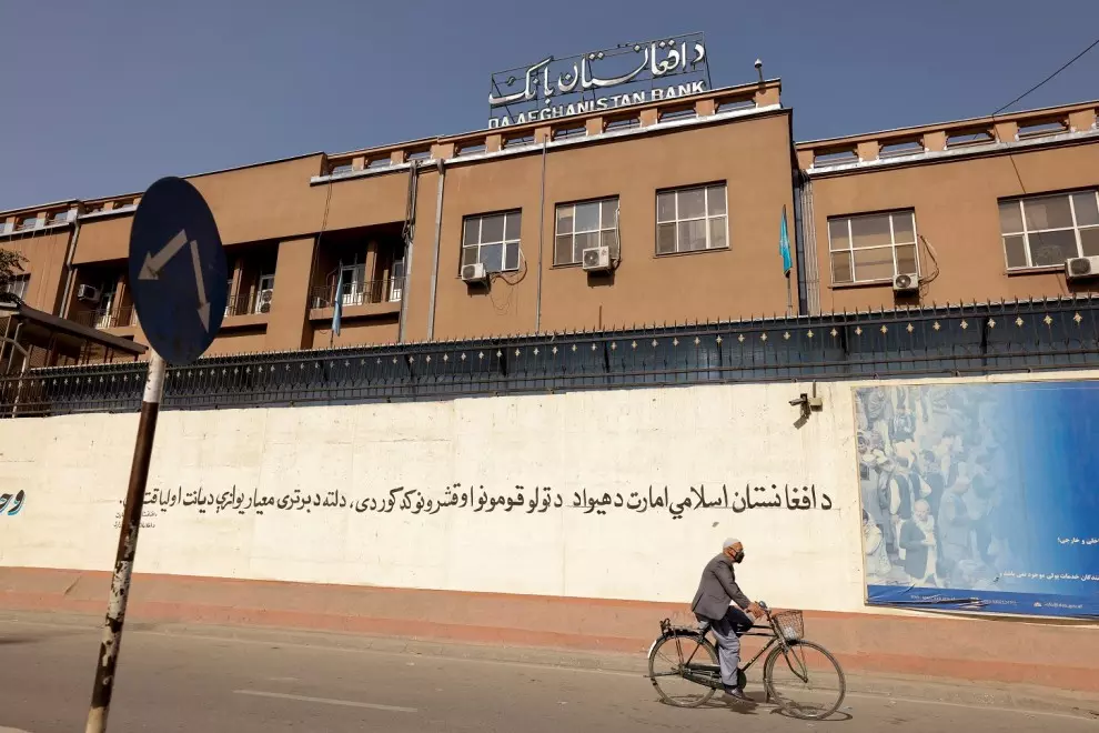 Un hombre en bicicleta pasa por delante del edificio del Banco de Afganistán, en Kabul. REUTERS/Jorge Silva