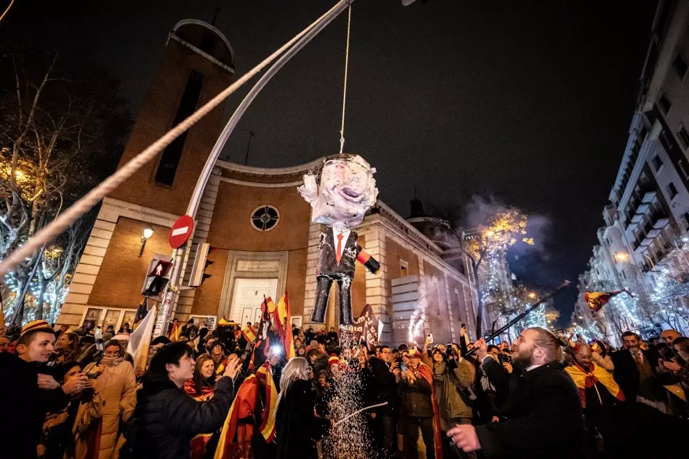 Decenas de personas celebran la entrada del año nuevo en la calle Ferraz golpeando un muñeco de Pedro Sánchez, a 1 de enero de 2024, en Madrid.