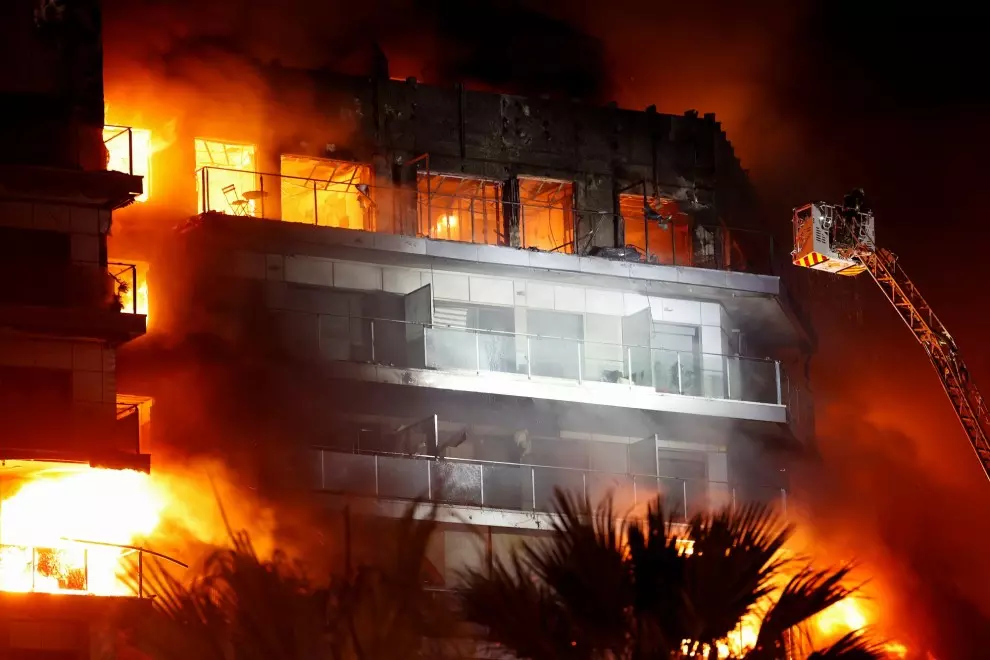 Firefighters work at the scene of a fire of apartment building in Valencia, Spain