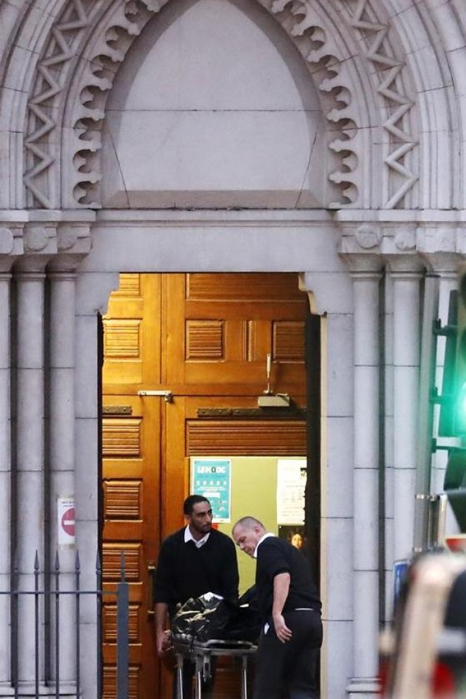 El cuerpo de una víctima es transportado fuera de la iglesia de la Basílica de Notre Dame por oficiales en Niza, Francia.