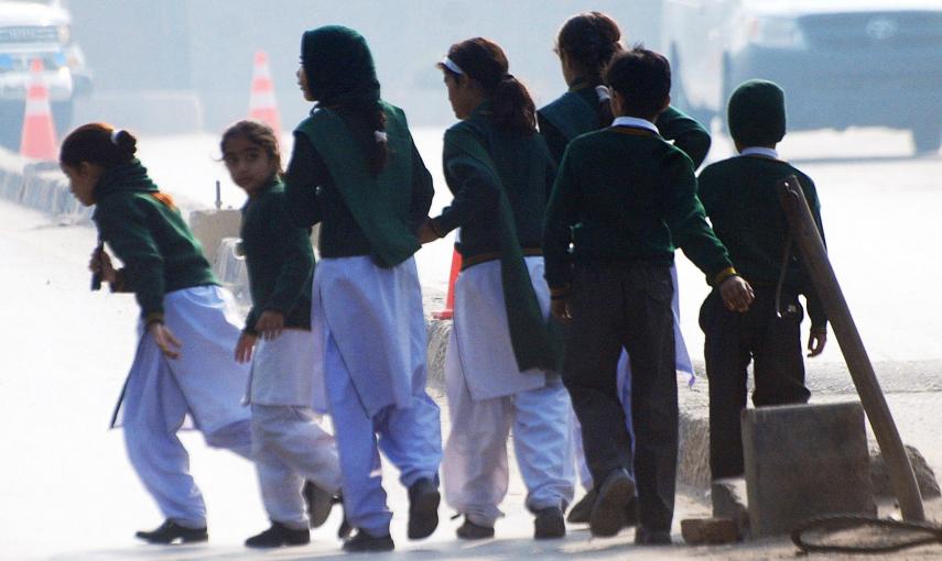 Unos niños cruzan la calle huyendo de la Escuela Militar, que ha sido atacada por los talibán en la ciudad paquistaní de Peshwar. REUTERS/Khuram Parvez