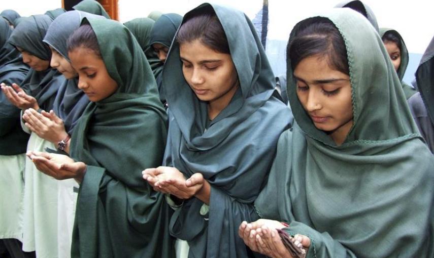 Varias alumnas rezan por los estudiantes asesinados alumnos en el ataque talibán contra un colegio gestionado por el Ejército en Peshawar, en una ceremonia celebrada en su escuela en Hyderabad (Pakistán). EFE/Nadeem Khawer