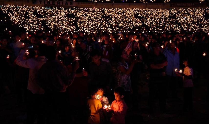 Cristianos indonesios sostienen velas durante una misa de navidad masiva en el estado Gelora Bung Karno, en Jakarta (Indonesia). /BEAWIHARTA (REUTERS)