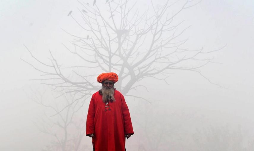 Un sufí pakistaní, en la calle un día de espesa niebla en Lahore. /ARIF ALI (AFP)