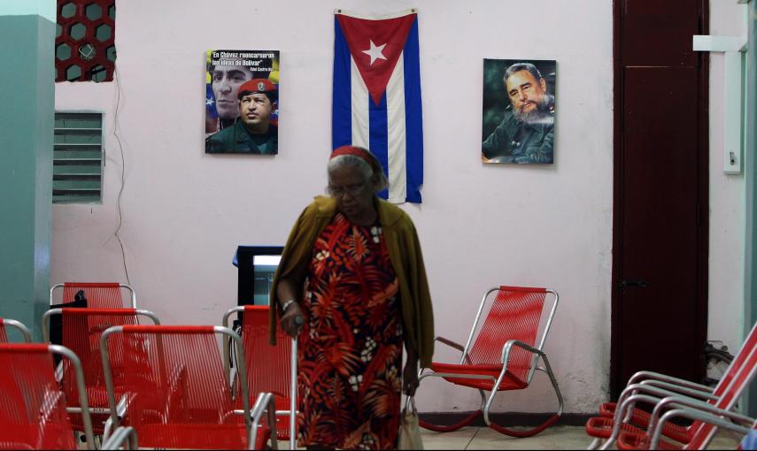 Una anciana camina en un Centro Para Atención a la Tercera Edad decorado con fotos de Fidel Castro y Hugo Chávez, en La Habana (Cuba). EFE/Alejandro Ernesto