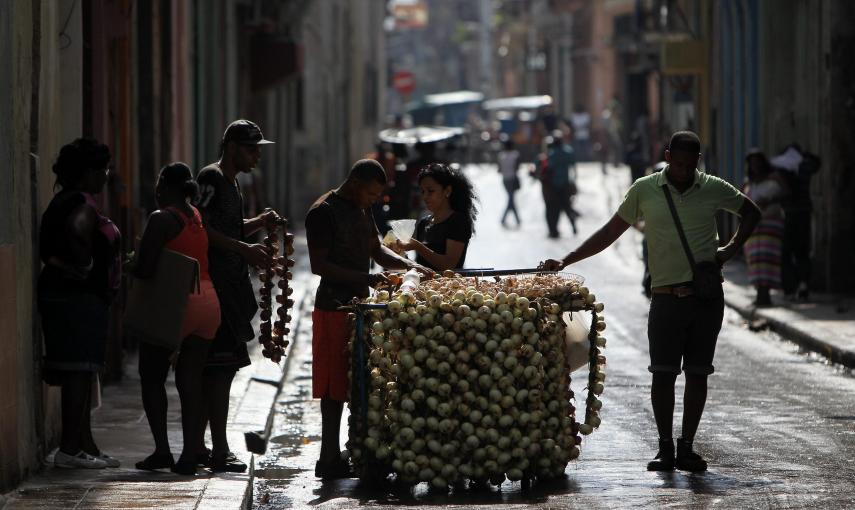 Dos hombres venden cebollas en una carretilla en una calle de La Habana (Cuba). EFE/Alejandro Ernesto