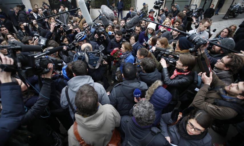 Las cámaras y los periodistas rodean a una mujer que lleva un ramo de rosas a las oficinas de 'Charlie Hebdo', tras el atentado que ha costado la vida a diez periodistas y dos policías. REUTERS/Charles Platiau