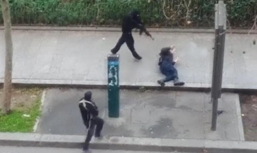 Imagen de un video amateur en el que se ve a uno de los atacantes de la revista 'Charlie Hebdo' disparando contra un policía que yace herido en el suelo. REUTERS