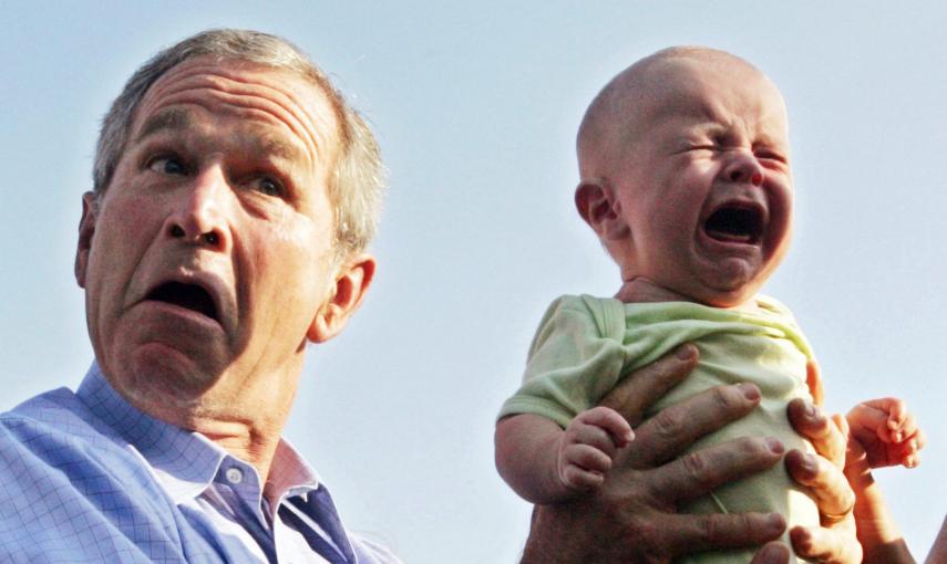 El presidente estadounidense, George W. Bush sostiene un bebé llorando a su llegada para una cena al aire libre con la canciller alemana, Angela Merkel, en Trinwillershagen, Alemania (13 de julio de  2006). REUTERS / Jim Bourg