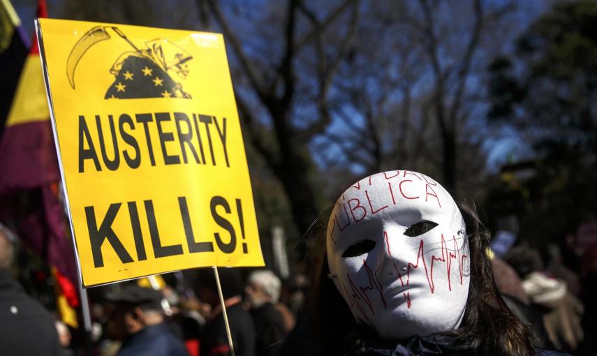 Una manifestante en la marcha de Madrid con una máscara y una pancarte que, en inglés, dice 'La austeridad mata'. REUTERS/Andrea Comas