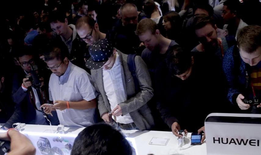 Una multitud de periodistas comprueban el Huawei Watch tras la rueda de prensa de presentación de dispositivos ponibles que la compañía china Huawei celebró el domingo en Barcelona, donde el lunes comienza de forma oficial el Mobile World Congress (MWC)
