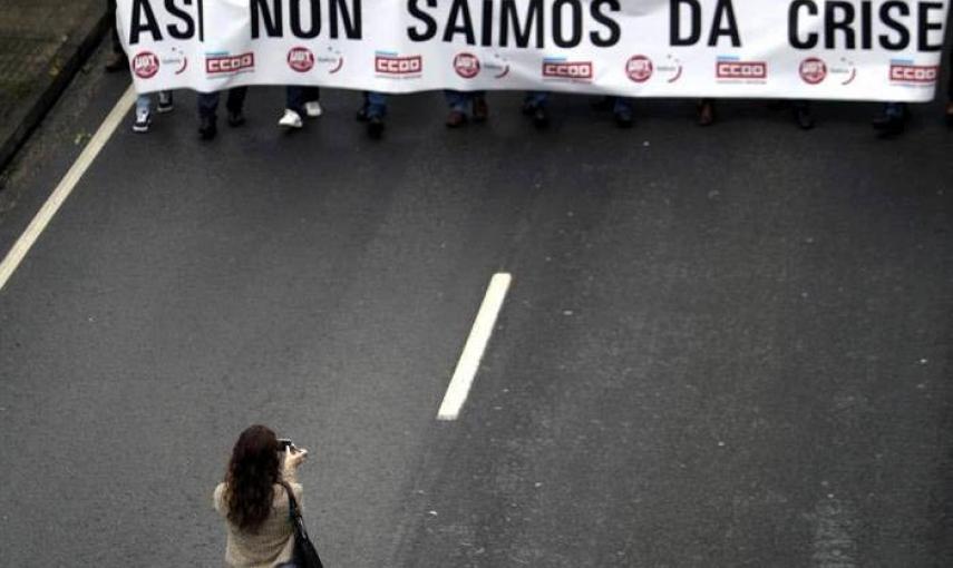 Una mujer fotografía la cabecera de la manifestación celebrada hoy en A Coruña para pedir más empleo y de mayor calidad, así como para instar a la derogación de la reforma laboral. / EFE / Carbalar