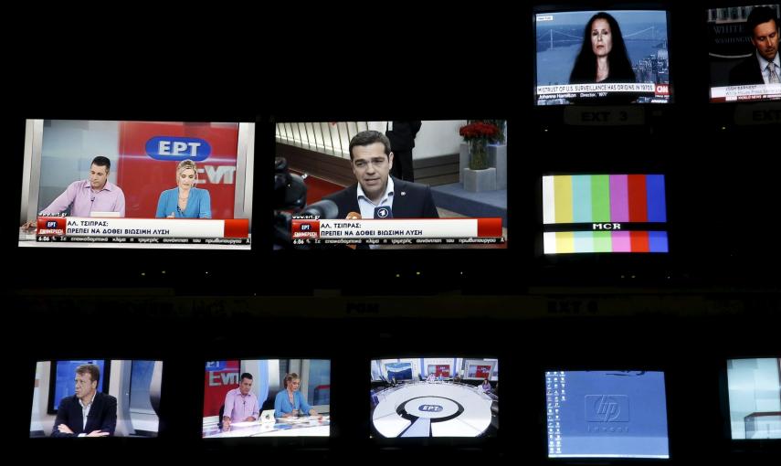 Greek Prime Minister Alexis Tsipras is seen on a monitor screen (C) at the control room during the first broadcast of state television ERT after its reopening./ REUTERS/Alkis Konstantinidis