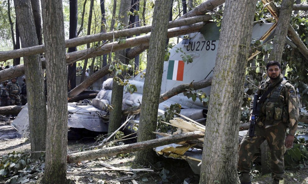 Un soldado indio al lado de los restos de un avión de las Fuerzas Aéreas en Soibugh en Budgam a unos 15 km de Srinagar (India), 24 de agosto de 2015. No se han producido daños personales en el accidente ya que el piloto consiguió eyectarse a tiempo antes