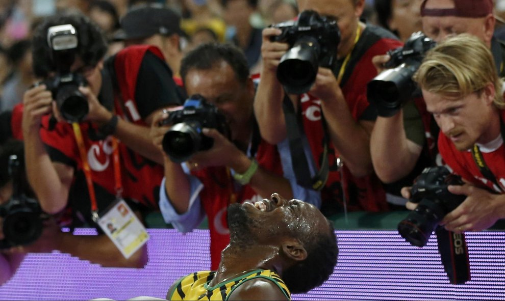 Usain Bolt celebra su victoria rodeado de la prensa en el Campeonato Mundial de IAAF en el Estadio Nacional de Pekín, China, 27 de agosto de 2015. REUTERS/Phil Noble