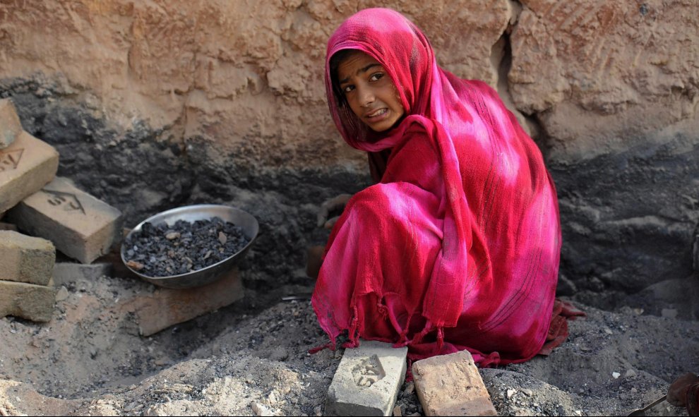 Una joven afgana apila ladrillos en Jalalabad (Afganistán), 27 de agosto de 2015. La economía afgana notado un pequeño empuje debido a la inversión extranjera así como a las ayudas económicas recibidas aunque la seguridad en el país continúa siendo su deb