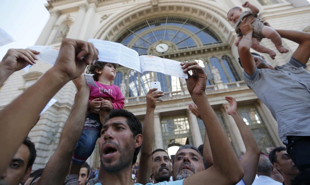 Cientos de inmigrantes protestan y muestran sus billetes a las puertas de la estación de Keleti, en Budapest. REUTERS