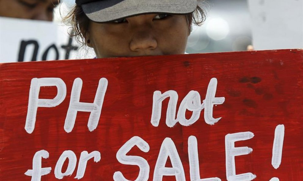 Una activista muestra un cartel con el mensaje "Filipinas no está a la venta" durante una protesta contra la próxima cumbre del Foro de Cooperación Económica Asia Pacífico (APEC). EFE/Mark R. Cristino
