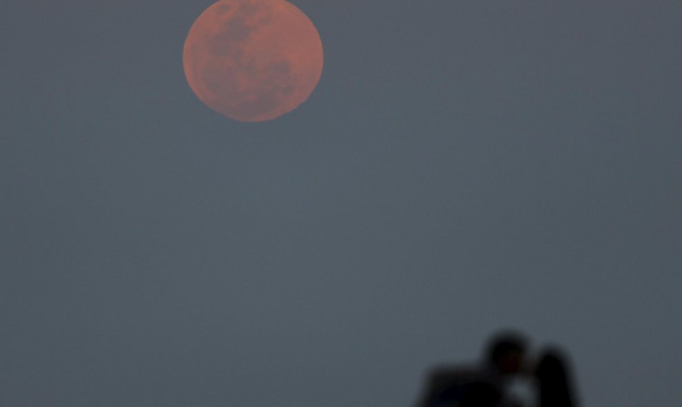 Una pareja se besa mientras observa la superluna desde Río de la Plata, en Buenos Aires.  REUTERS/Enrique Marcarian