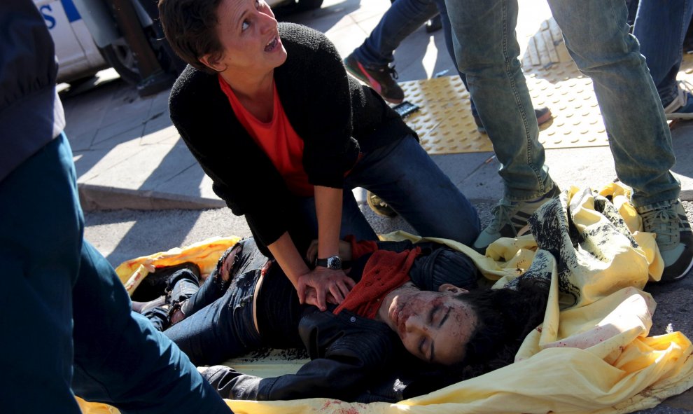 Una mujer atiende a una herida por las explosiones en Ankara, durante una marcha por la paz de los pro-kurdos. REUTERS/Tumay Berkin