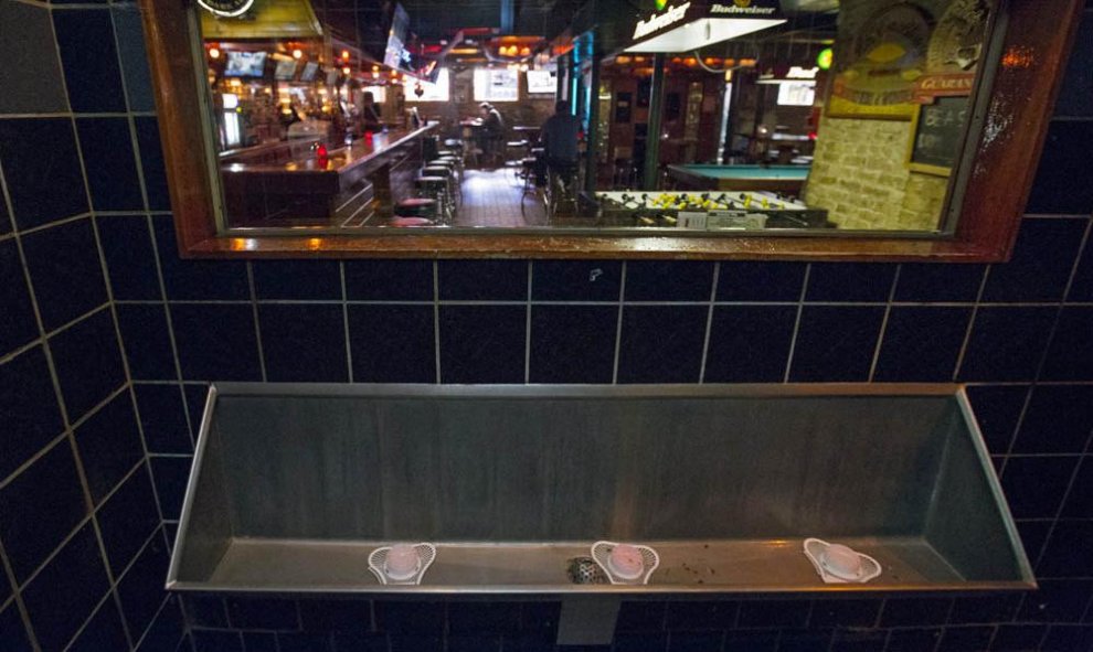 Un espejo unidireccional sobre los urianrios de una taberna Chicago (EEUU). REUTERS / Jim Young