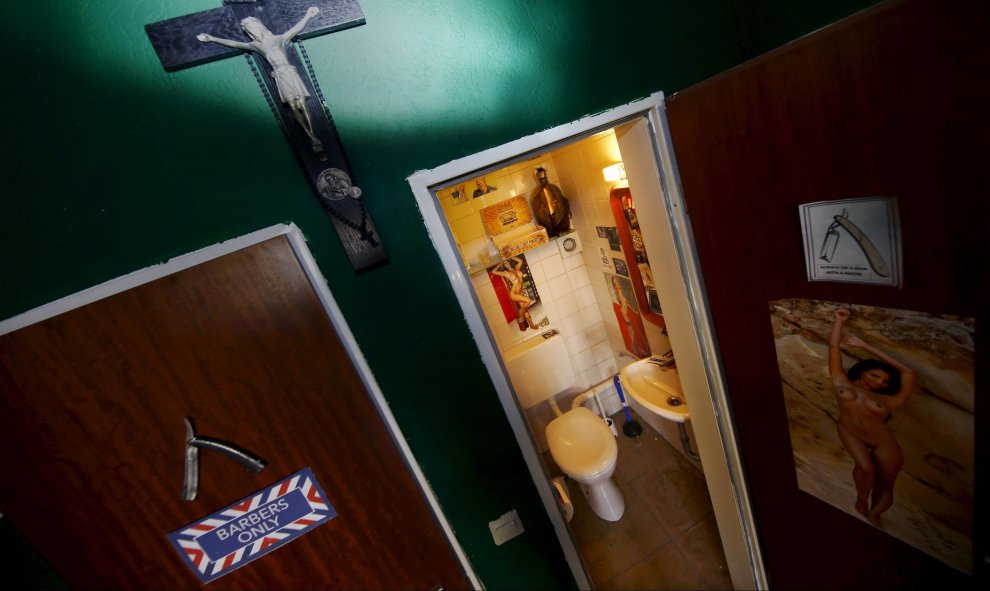 Una cruz cuelga entre los cuartos de baño en una barbería en Fráncfort (Alemania). REUTERS / Kai Pfaffenbach