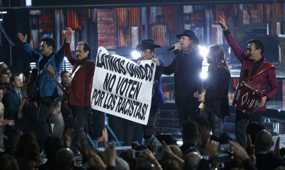 'Mana' junto al grupo 'Los tigres del norte' agarran una pancarta durante su actuación "Somos más americanos" en los Latin Grammy Awards (Las Vegas). REUTERS/Mario Anzuoni