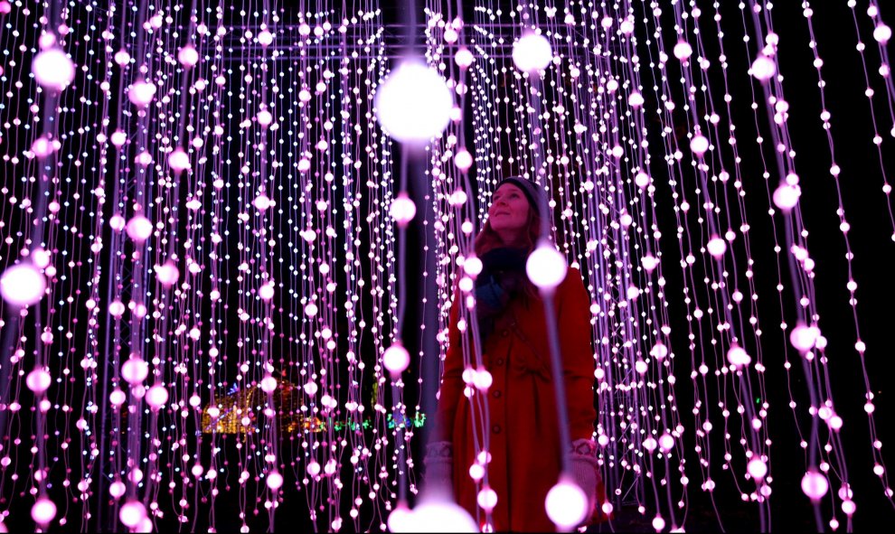 Una mujer entre la iluminación del photo-call navideño para el 'Kew Festival' en Londres. REUTERS/Neil Hall
