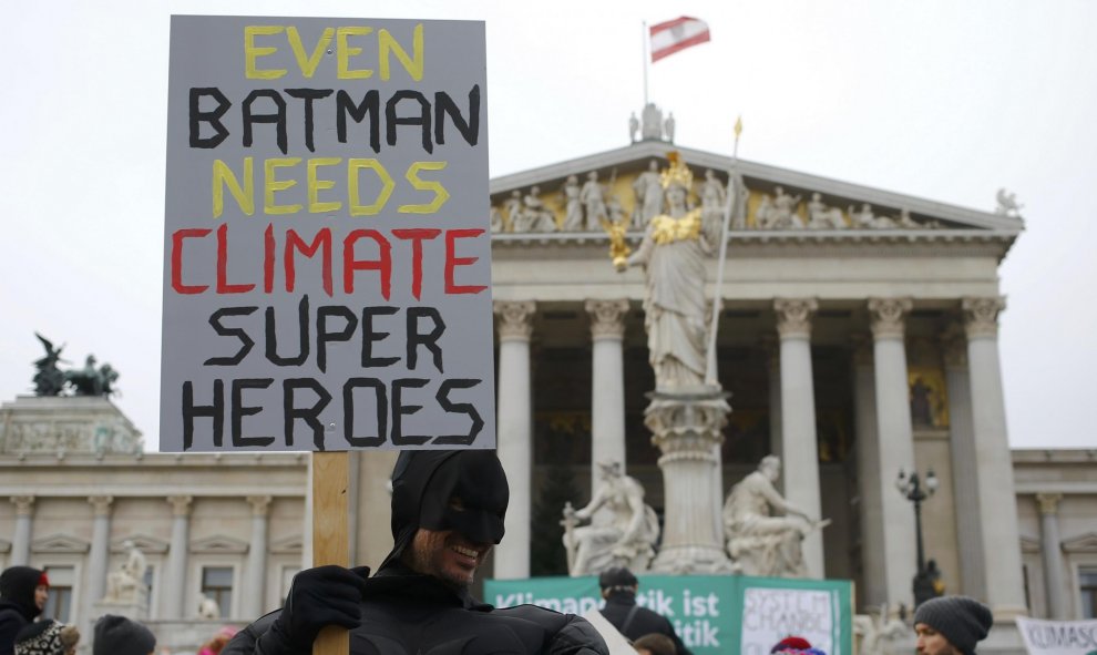 Un manifestante disfrazado de Batman en Viena delante del Parlamento austriaco lleva una pancarta que dice: "Incluso Batman necesita súper héroes del clima" . REUTERS / Leonhard Foeger