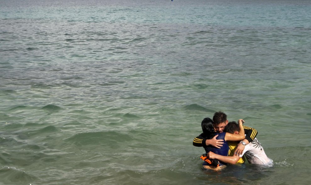 Un inmigrante cubano abraza a su hija y a su amigo después de que esta cruzase la frontera desde Colimbia a través del río La Miel. Provincia de Guna Yala. REUTERS/Carlos Jasso