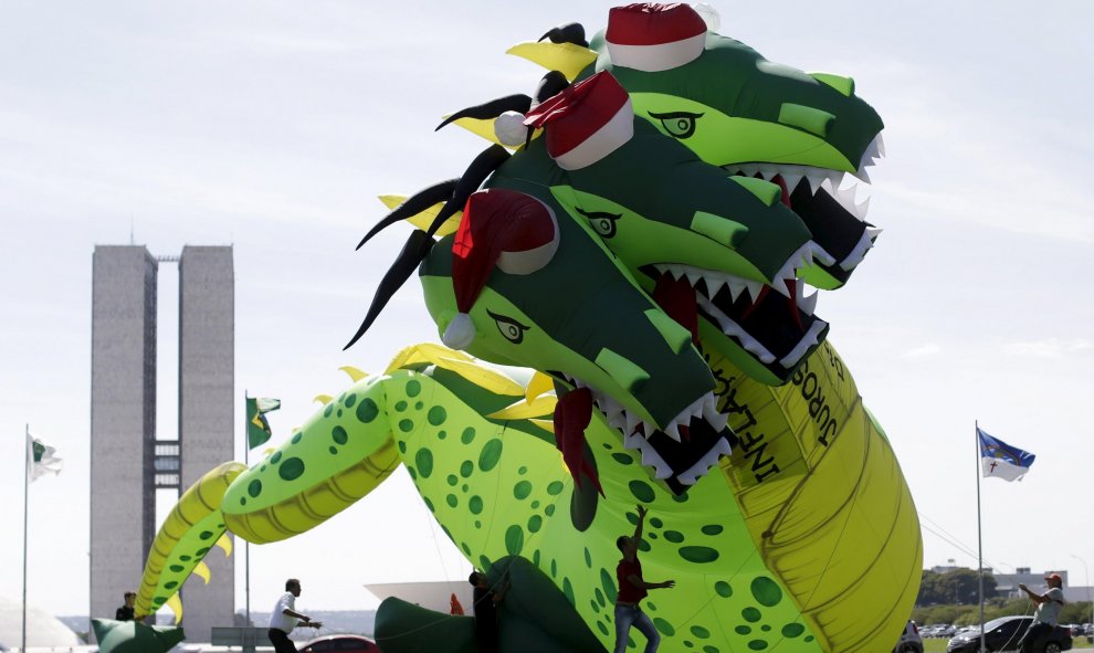 Unos brasileños levantan un dragón inflable contra la inflación, el desempleo y las altas tasas en frente del Congreso Nacional en Brasilia, Brasil." REUTERS/Ueslei Marcelino