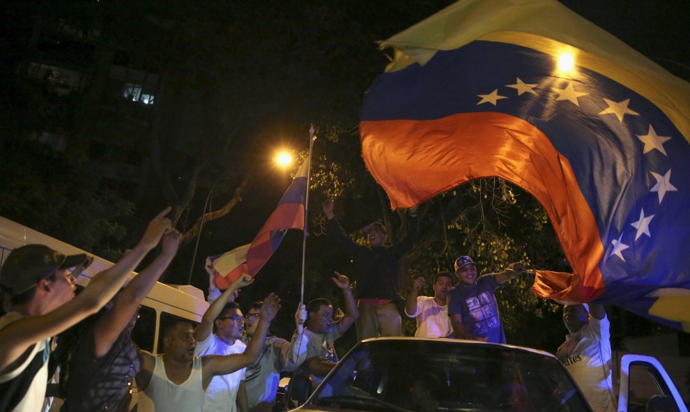 Los partidarios de la oposición ondean la bandera de Venezuela mientras celebran el resultado de las elecciones generales del país latinoamericano. REUTERS/Nacho Doce